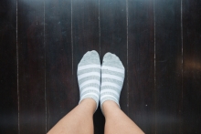 pair of feet with socks on hardwood floors